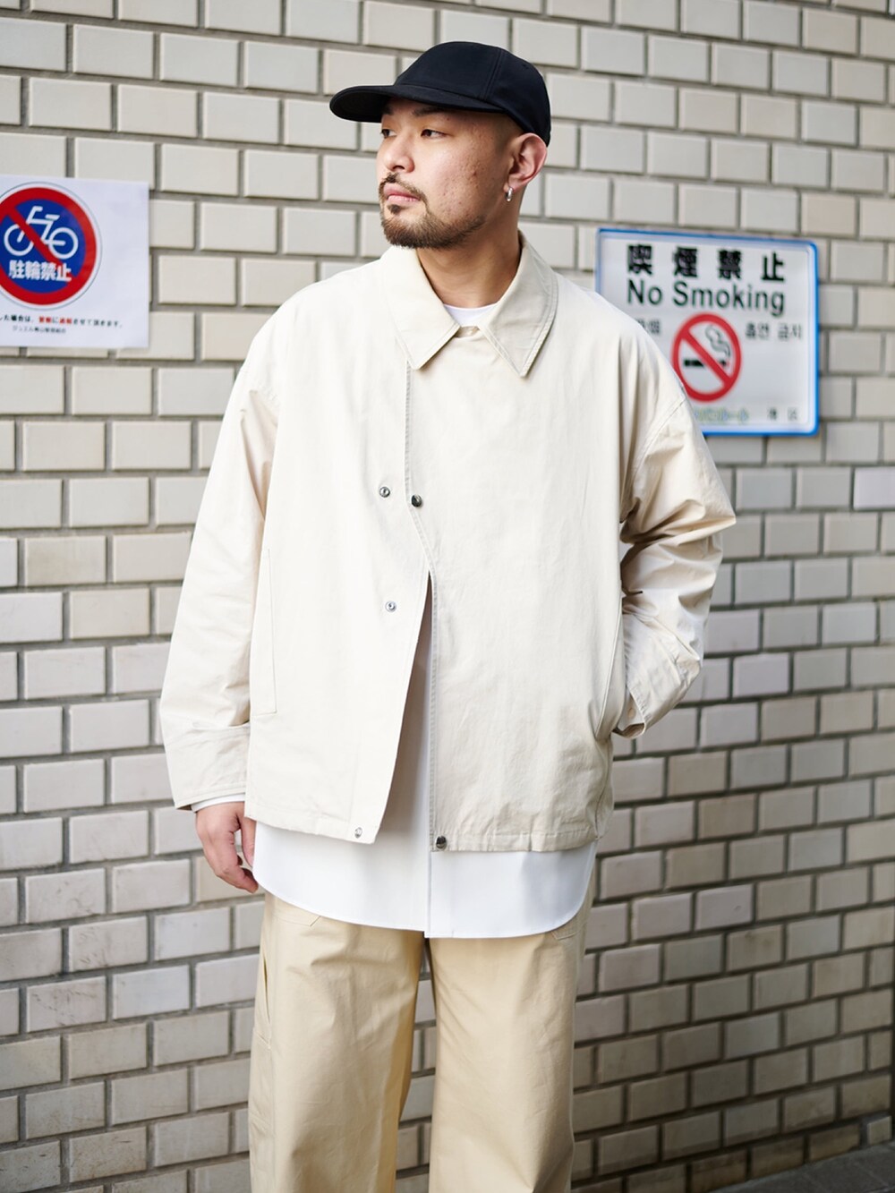 ベージュ系のブルゾン、ホワイト系のシャツ/ブラウス、ベージュ系のカーゴパンツを着用したメンズの春コーディネートの2枚目の写真