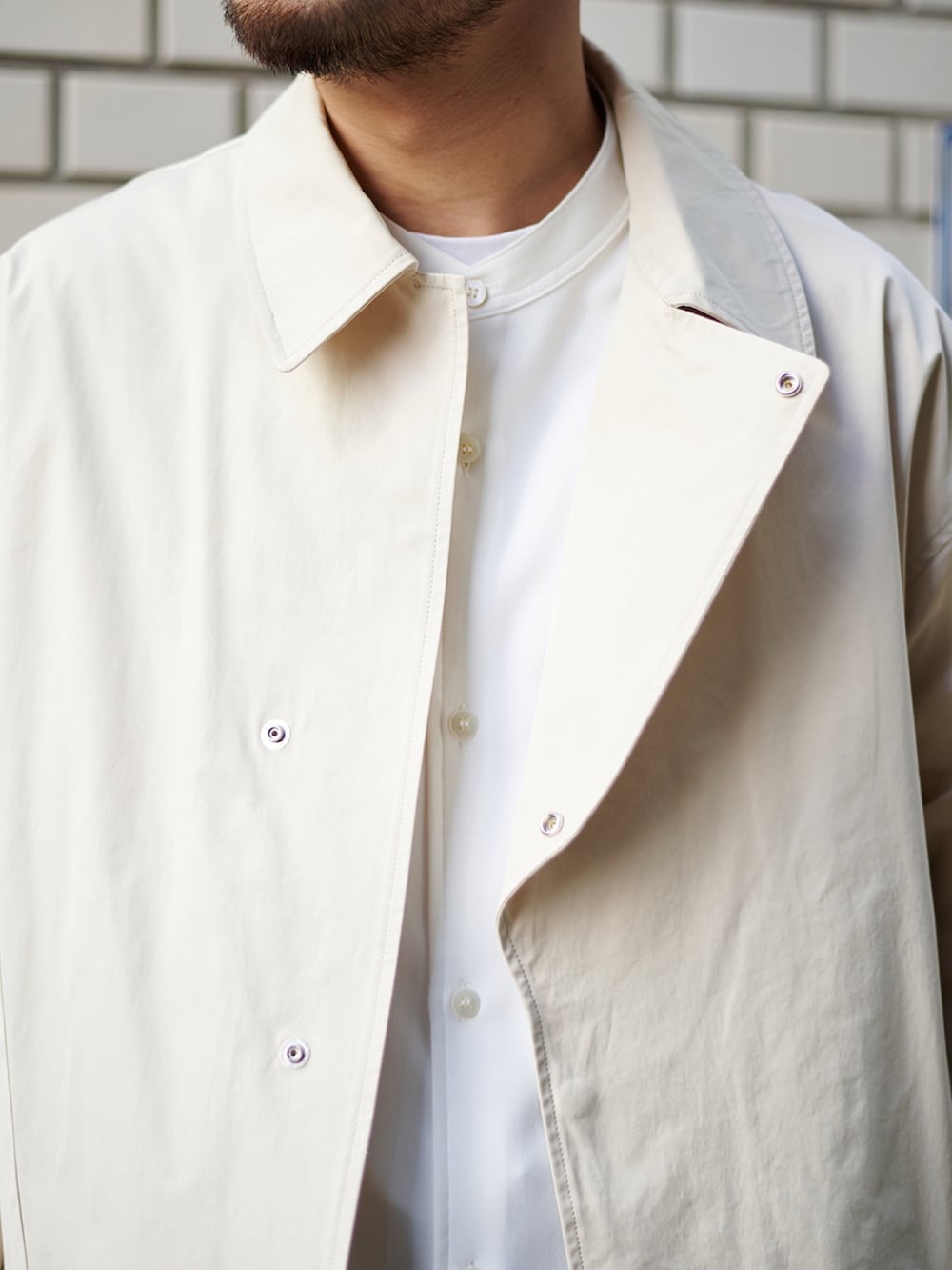 ベージュ系のブルゾン、ホワイト系のシャツ/ブラウス、ベージュ系のカーゴパンツを着用したメンズの春コーディネートの4枚目の写真