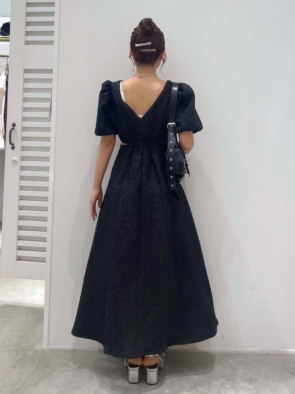 シルバー系のサンダル、ホワイト系のキャミソール、ブラック系のショルダーバッグを着用したレディースの夏コーディネートの3枚目の写真