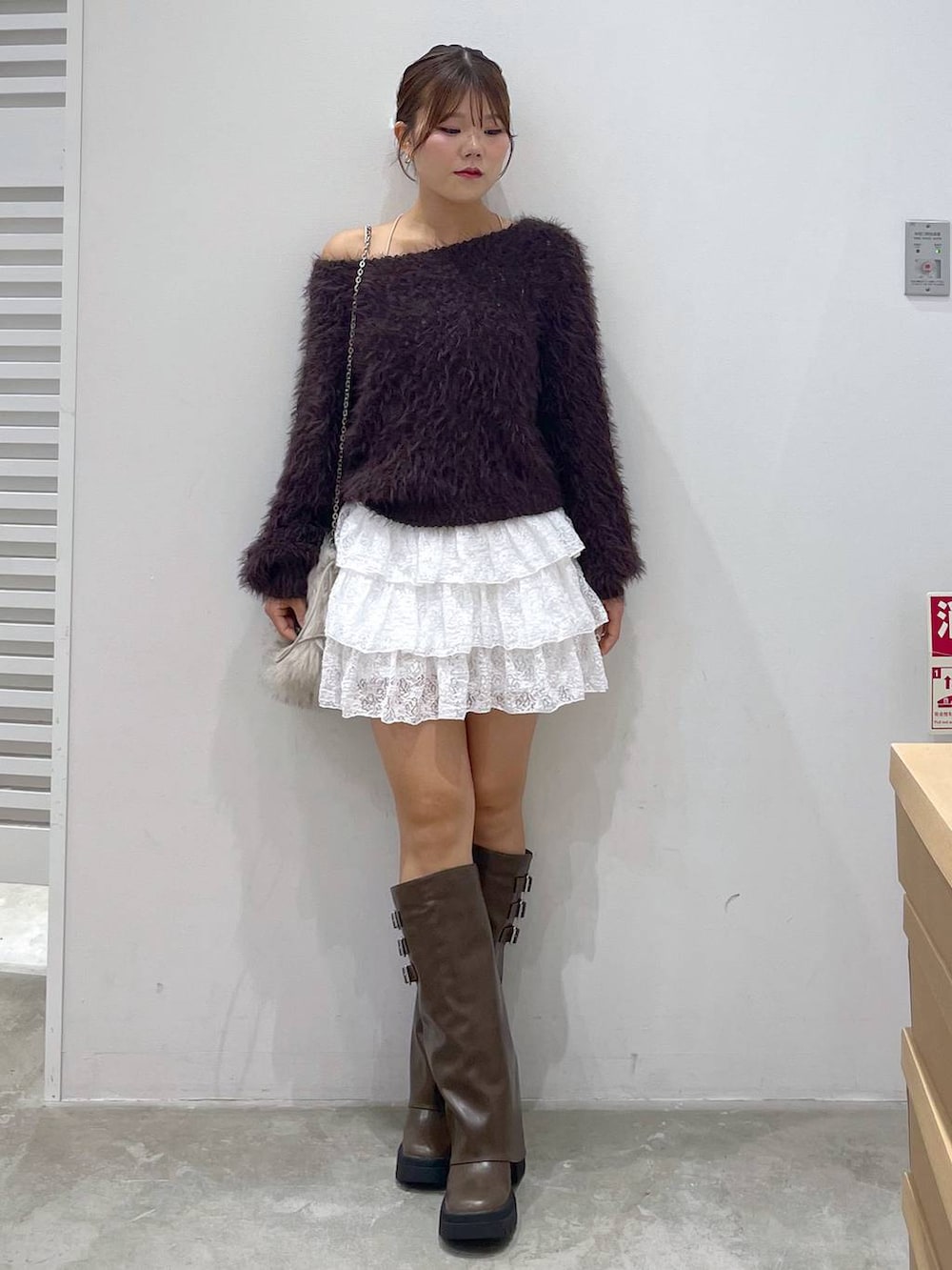 ブラウン系のブーツ、ホワイト系のスカート、ブラウン系のニット/セーターを着用したレディースの秋コーディネートの5枚目の写真