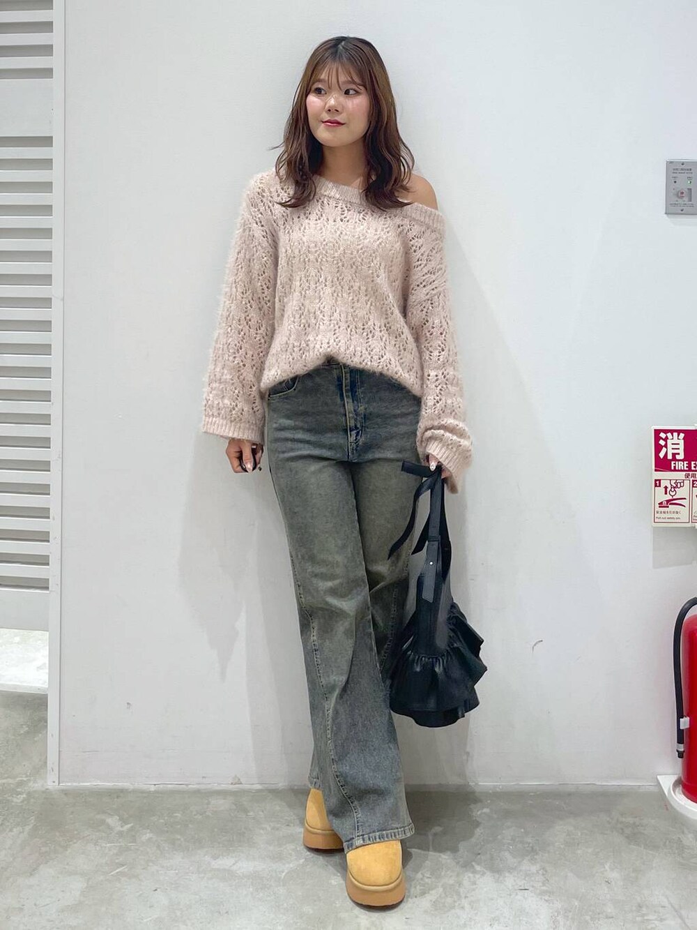 イエロー系のブーツ、ピンク系のニット/セーター、ブルー系のデニムパンツを着用したレディースの秋コーディネートの5枚目の写真