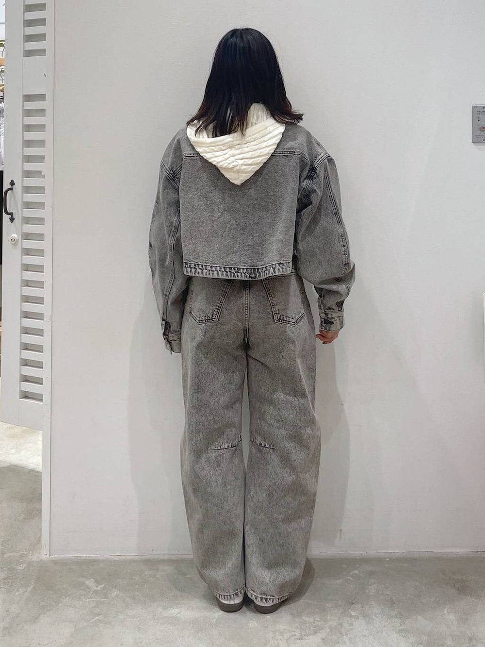 グレー系のデニムジャケット、グレー系のデニムパンツ、ホワイト系のニット/セーターを着用したレディースの冬コーディネートの3枚目の写真