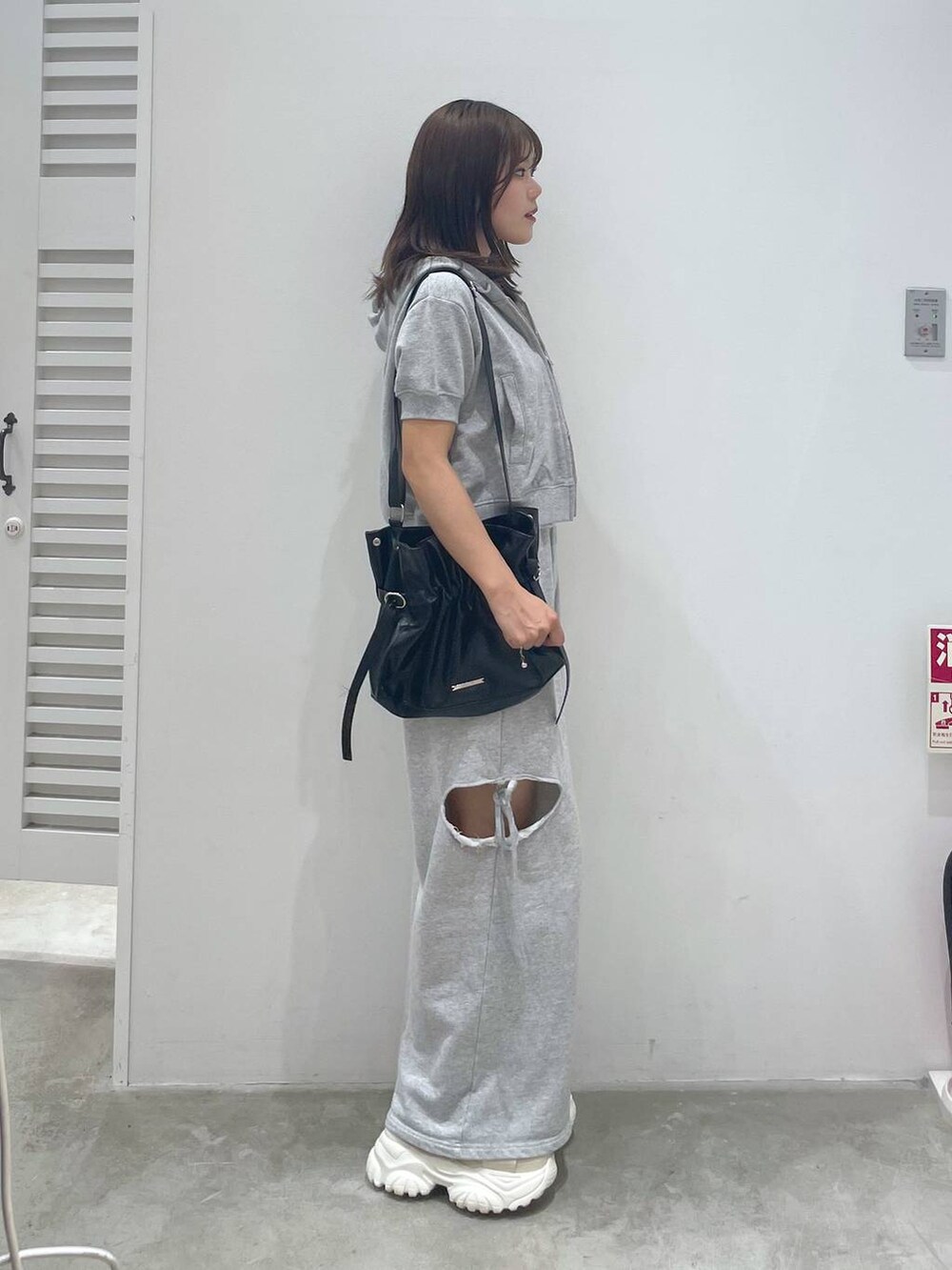 ホワイト系のサンダル、グレー系のスウェットパンツ、グレー系のパーカーを着用したレディースの夏コーディネートの2枚目の写真