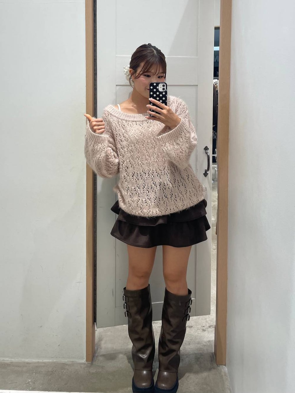 ブラウン系のブーツ、ピンク系のニット/セーター、ブラウン系のスカートを着用したレディースの秋コーディネートの3枚目の写真