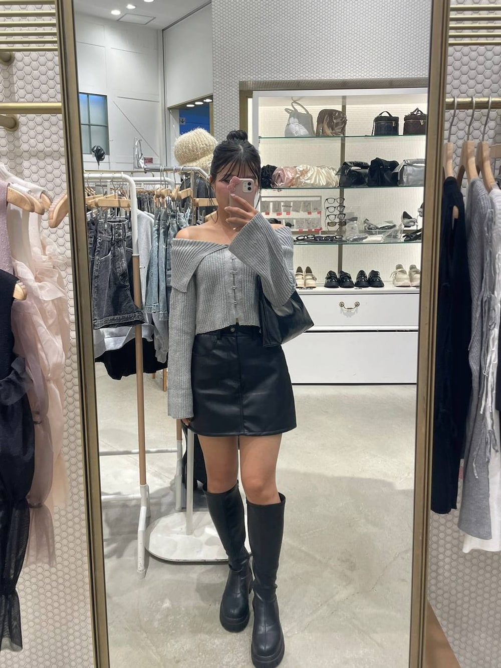 ブラック系のスカート、グレー系のニット/セーター、ブラック系のブーツを着用したレディースの秋コーディネートの2枚目の写真