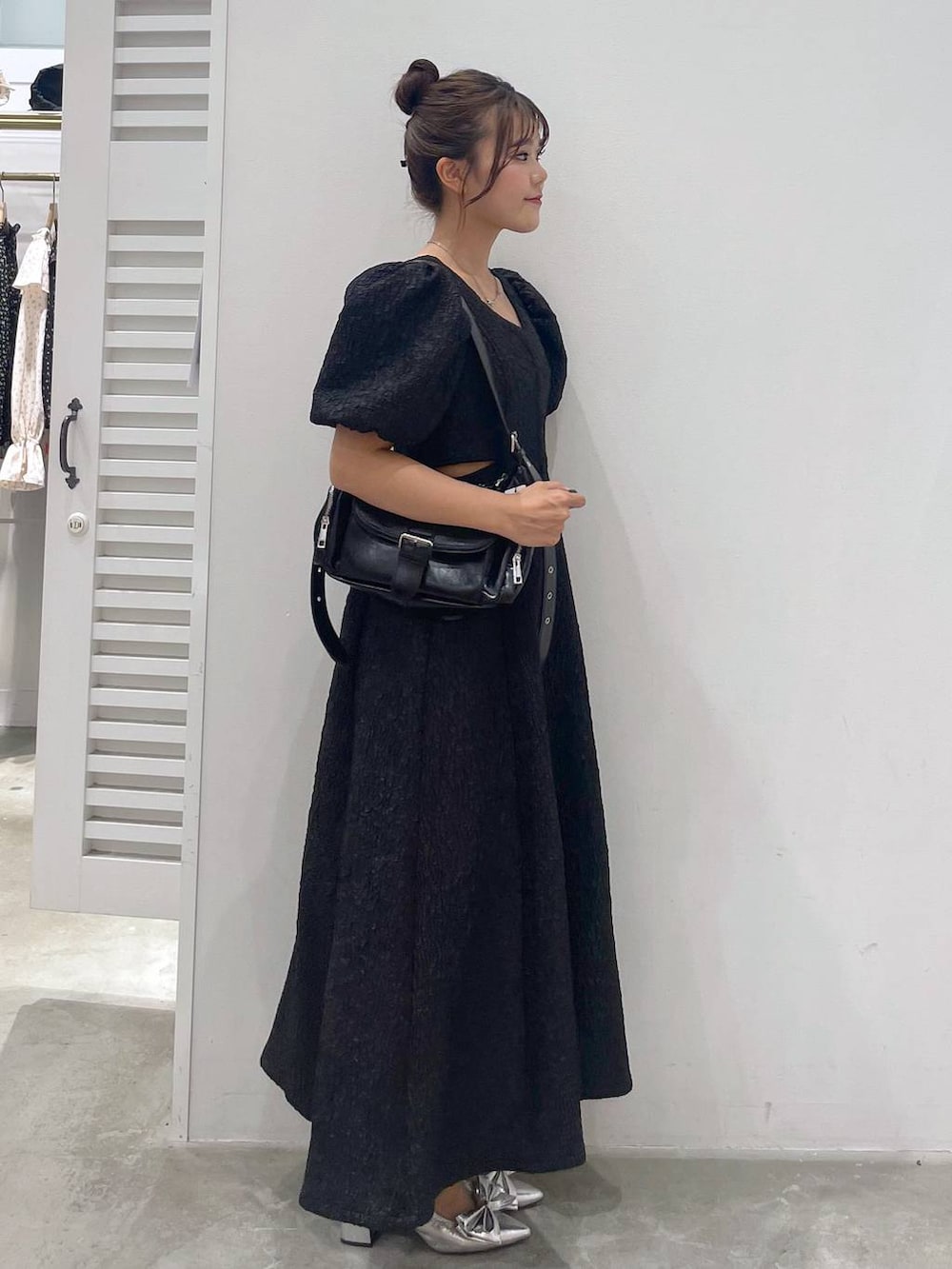 シルバー系のサンダル、ホワイト系のキャミソール、ブラック系のショルダーバッグを着用したレディースの夏コーディネートの2枚目の写真