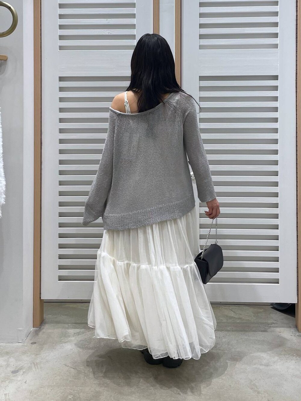 ホワイト系のワンピース、ブラック系のローファー、ブラック系のショルダーバッグを着用したレディースの春コーディネートの5枚目の写真