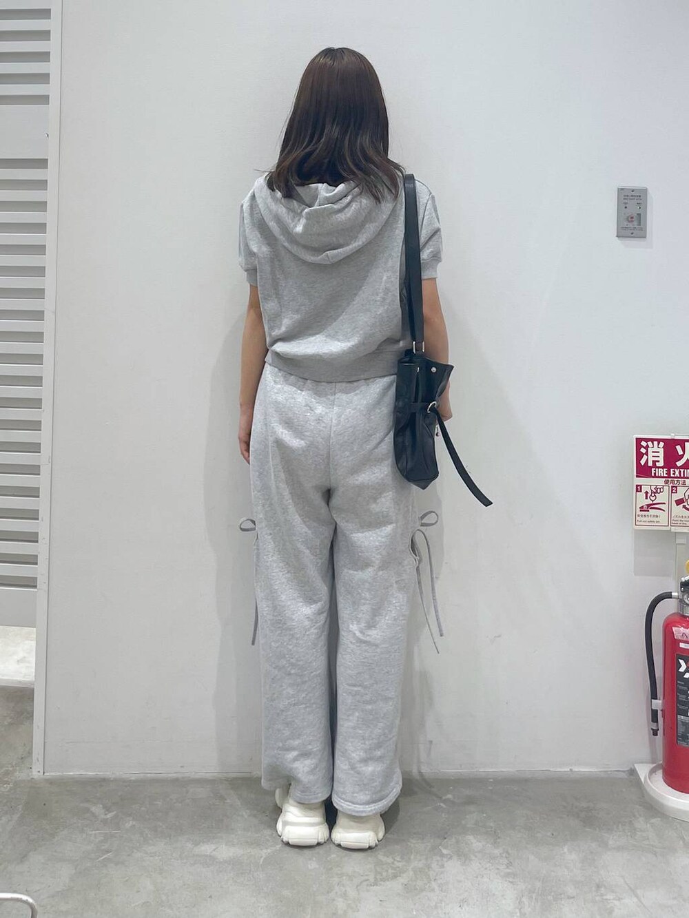 ホワイト系のサンダル、グレー系のスウェットパンツ、グレー系のパーカーを着用したレディースの夏コーディネートの3枚目の写真