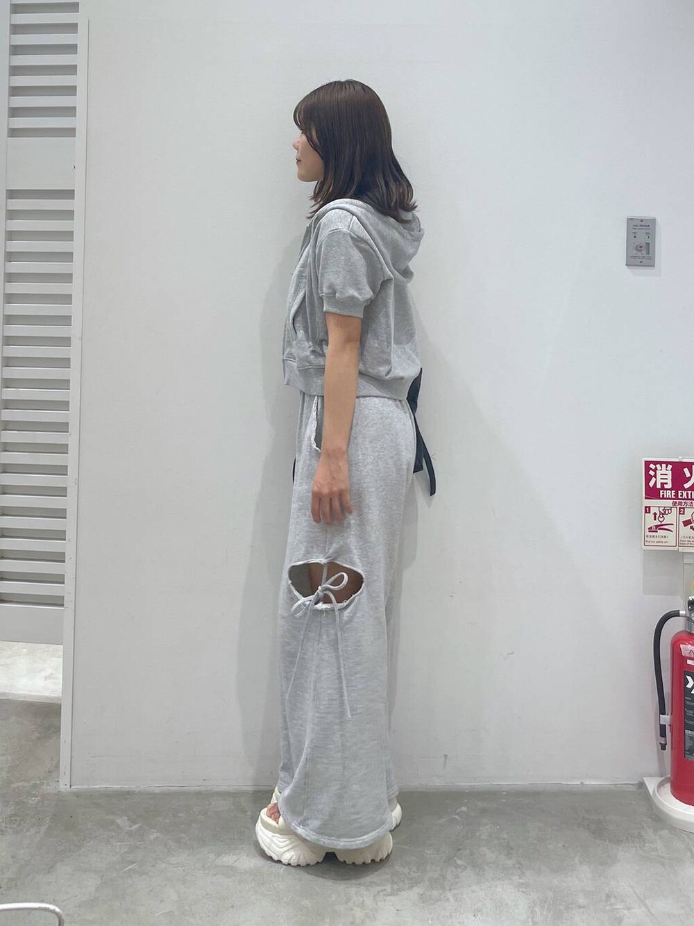 ホワイト系のサンダル、グレー系のスウェットパンツ、グレー系のパーカーを着用したレディースの夏コーディネートの4枚目の写真