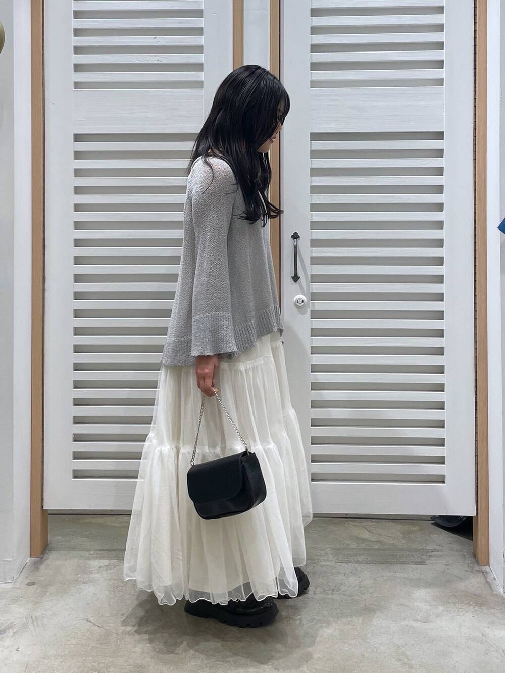 ホワイト系のワンピース、ブラック系のローファー、ブラック系のショルダーバッグを着用したレディースの春コーディネートの3枚目の写真