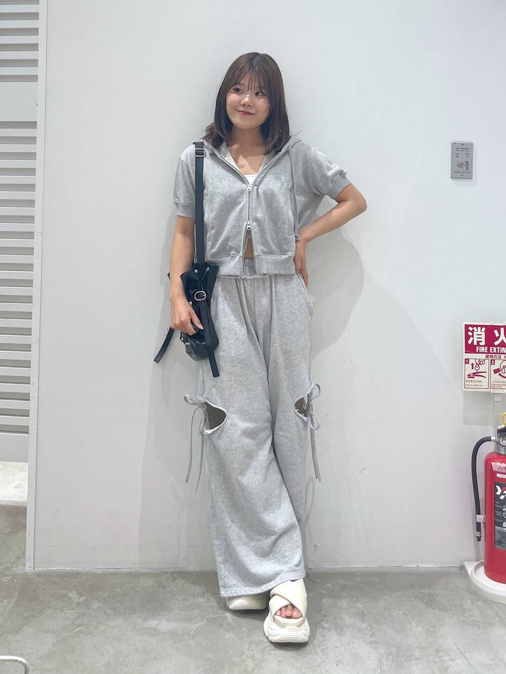 ホワイト系のサンダル、グレー系のスウェットパンツ、グレー系のパーカーを着用したレディースの夏コーディネートの5枚目の写真