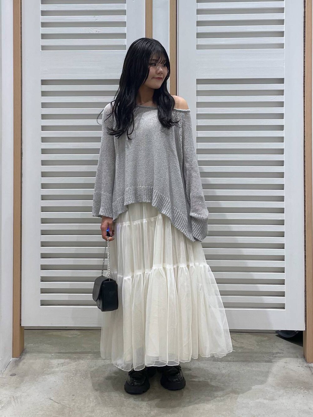 ホワイト系のワンピース、ブラック系のローファー、ブラック系のショルダーバッグを着用したレディースの春コーディネートの7枚目の写真