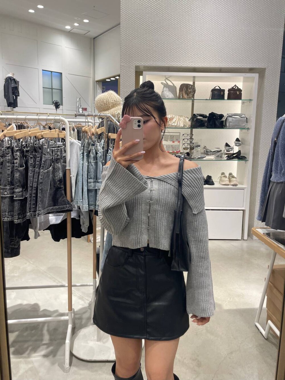 ブラック系のスカート、グレー系のニット/セーター、ブラック系のブーツを着用したレディースの秋コーディネートの4枚目の写真