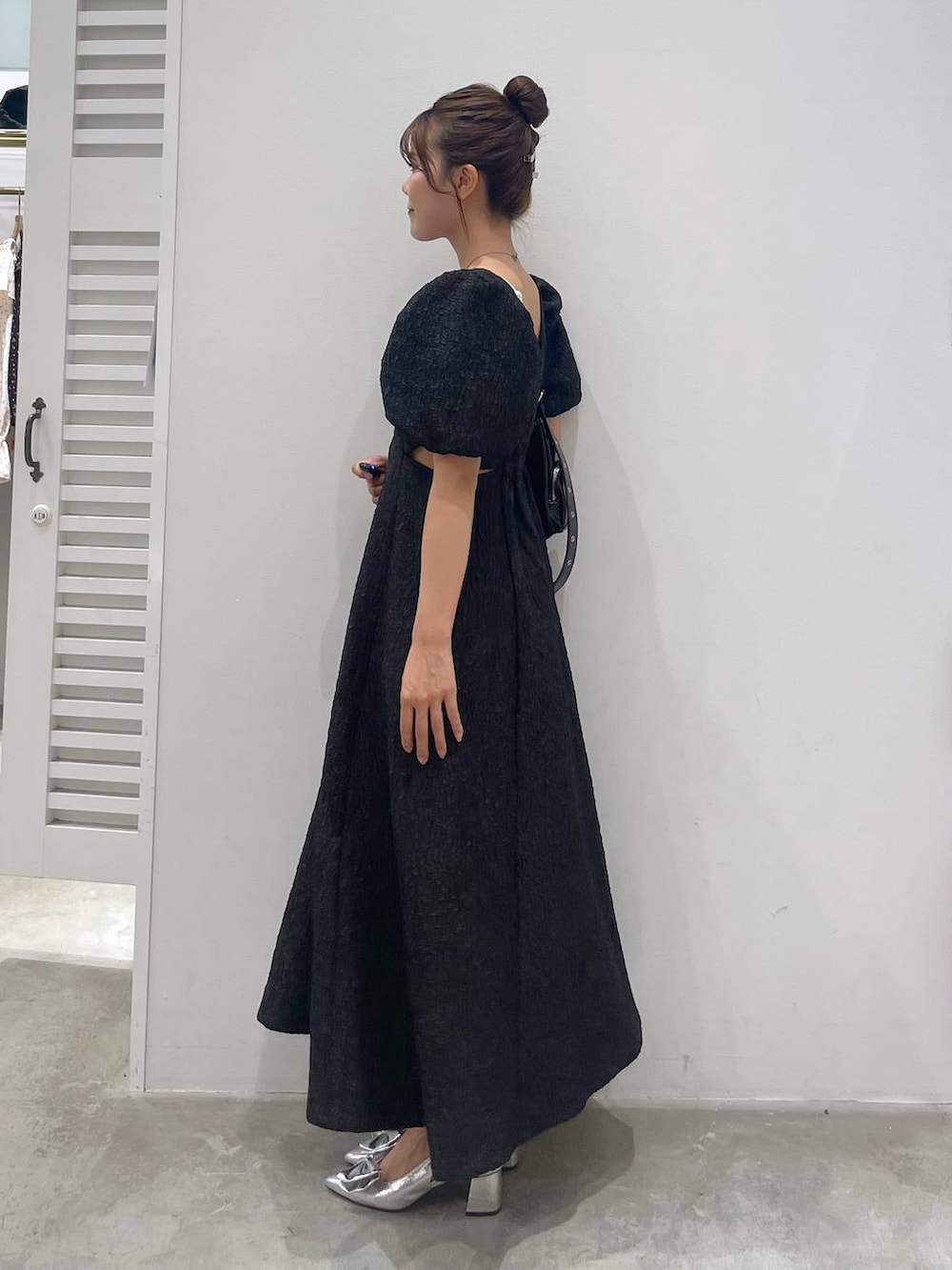 シルバー系のサンダル、ホワイト系のキャミソール、ブラック系のショルダーバッグを着用したレディースの夏コーディネートの4枚目の写真