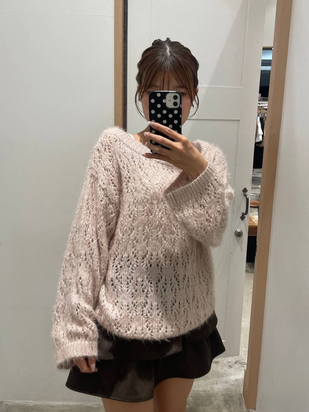 ブラウン系のブーツ、ピンク系のニット/セーター、ブラウン系のスカートを着用したレディースの秋コーディネートの2枚目の写真