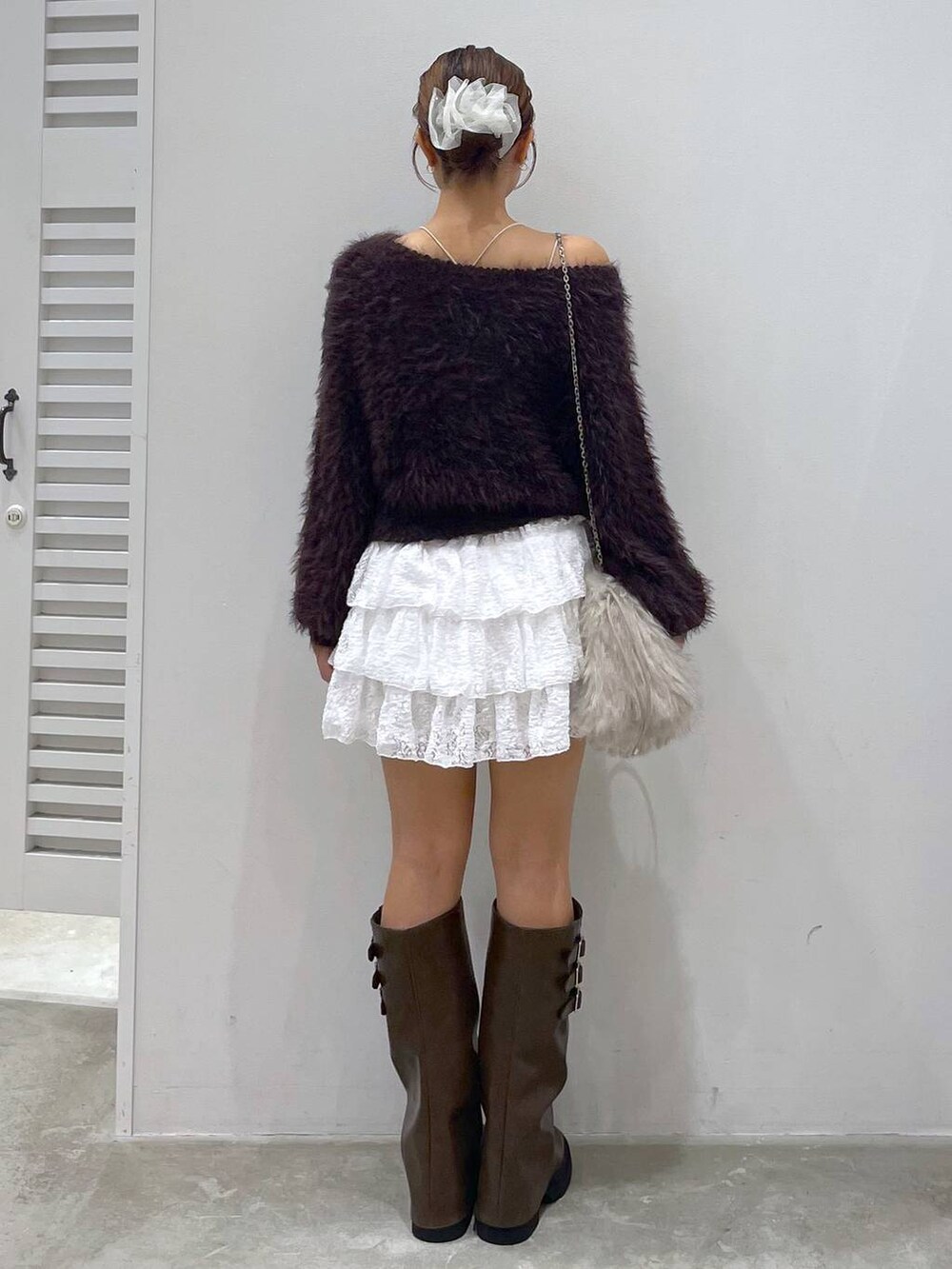 ブラウン系のブーツ、ホワイト系のスカート、ブラウン系のニット/セーターを着用したレディースの秋コーディネートの3枚目の写真