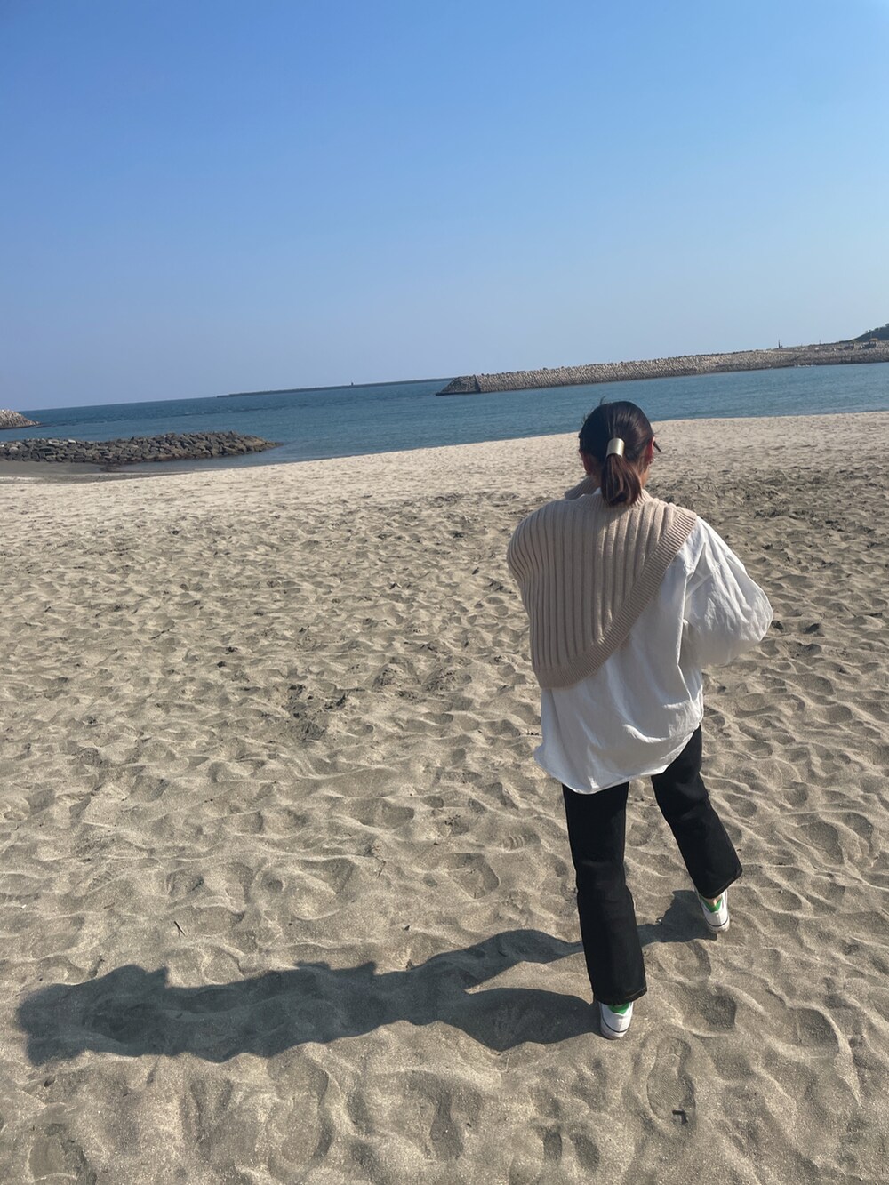 ベージュ系のトップスを着用したレディースの春コーディネートの2枚目の写真