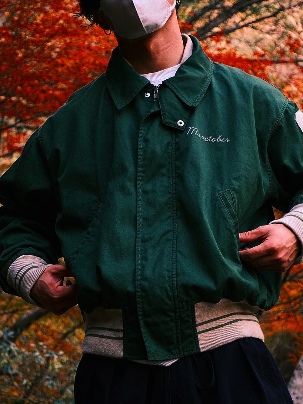 グリーン系のスタジャン、ブラック系のスラックス、ブラック系のスニーカーを着用したメンズの秋コーディネートの3枚目の写真