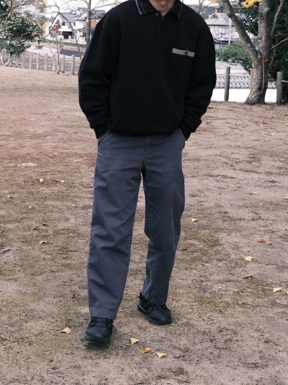 ブラック系のポロシャツ、グレー系のその他パンツ、ブラック系のスニーカーを着用したメンズの冬コーディネートの3枚目の写真