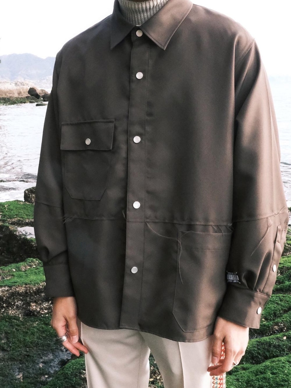 グリーン系のシャツ/ブラウス、ホワイト系のその他パンツ、ブラック系のローファーを着用したメンズの冬コーディネートの2枚目の写真