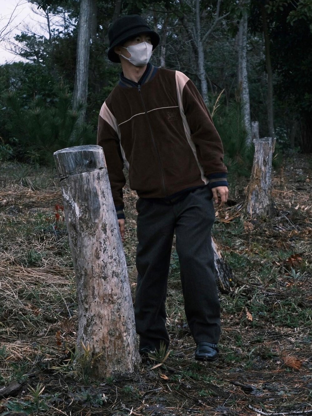 ブラウン系のトップス、ブラウン系のスラックス、ブラック系のローファーを着用したメンズの冬コーディネートの3枚目の写真