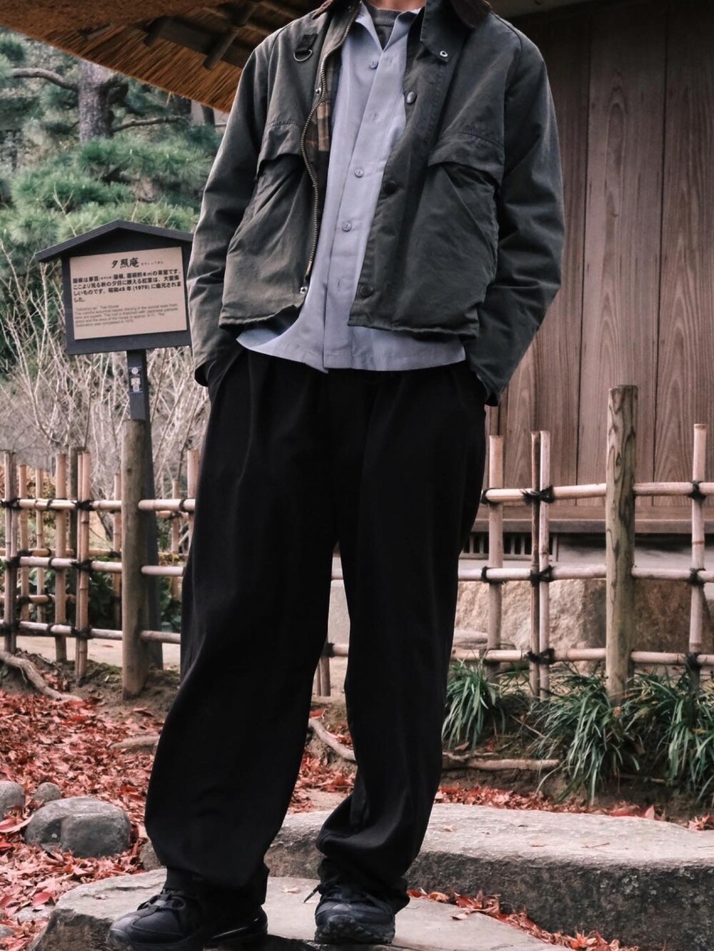 ブラック系のスラックス、ブラック系のスニーカー、グリーン系のミリタリージャケットを着用したメンズの冬コーディネートの2枚目の写真