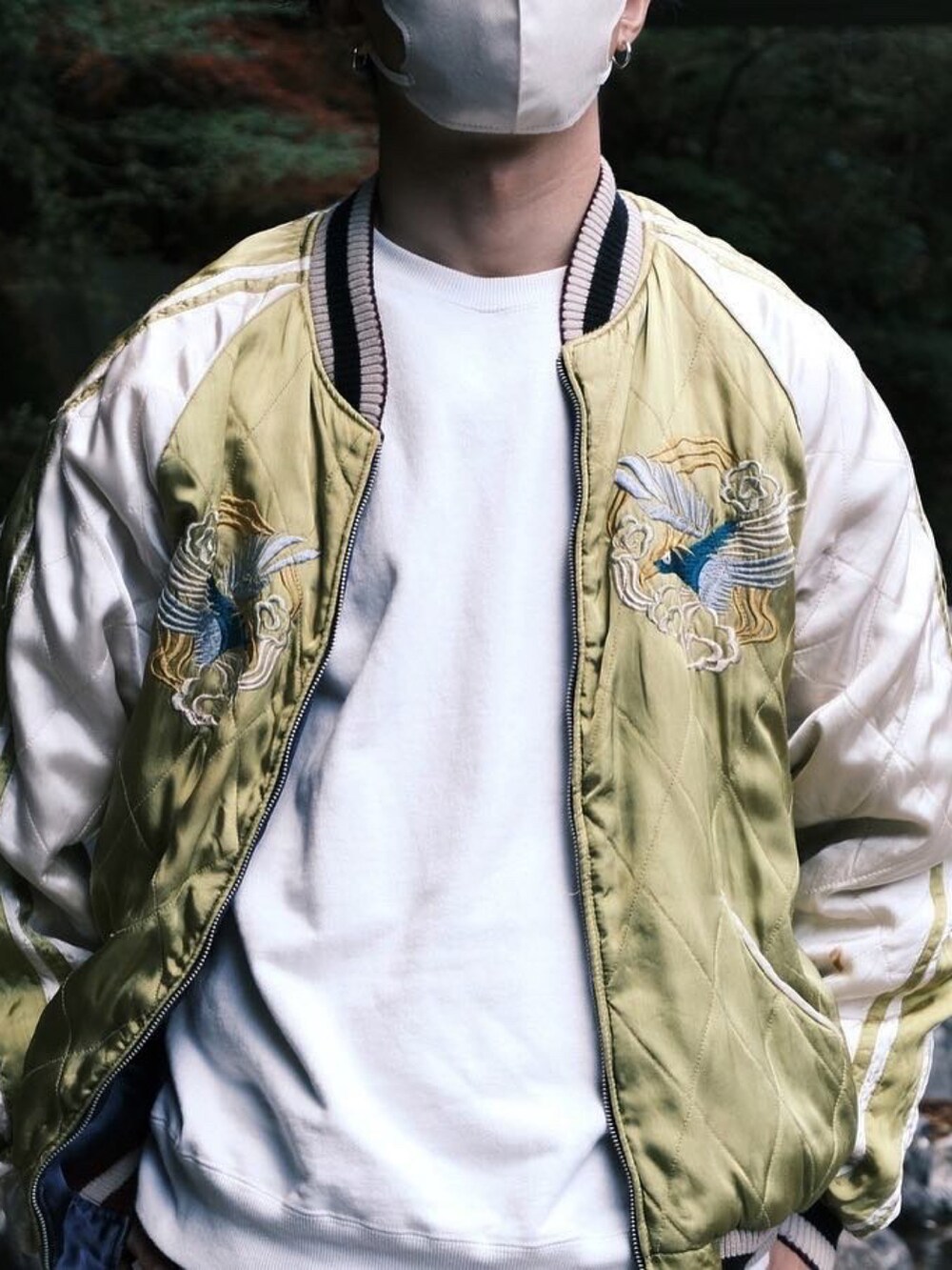 ブルー系のデニムパンツ、グリーン系のスニーカー、イエロー系のスカジャンを着用したメンズの秋コーディネートの2枚目の写真