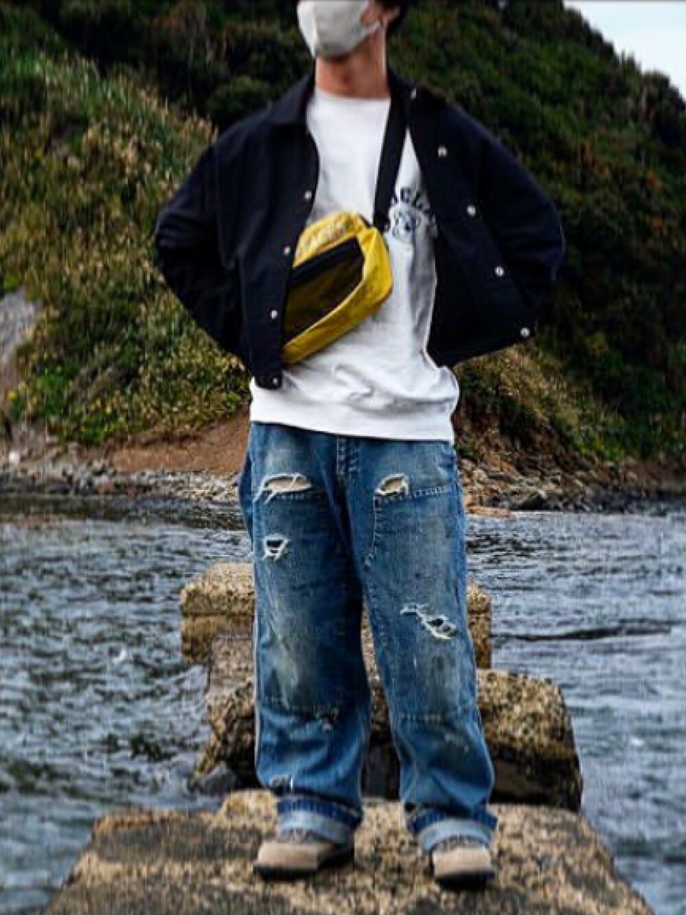 ブラック系のナイロンジャケット、ブルー系のデニムパンツ、グレー系のブーツを着用したメンズの秋コーディネートの2枚目の写真