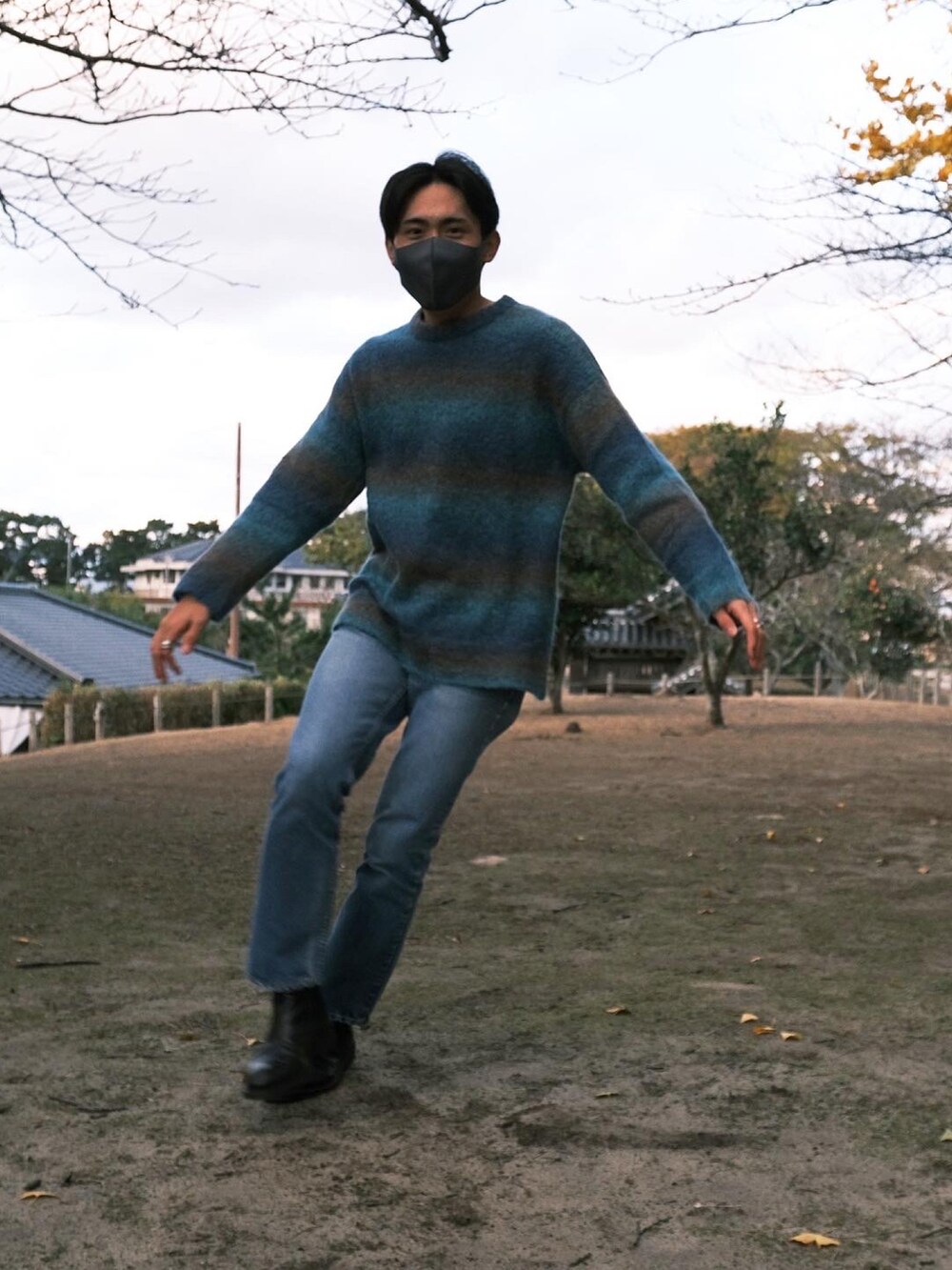 ブルー系のニット/セーター、ブルー系のデニムパンツ、ブラック系のブーツを着用したメンズの冬コーディネートの2枚目の写真