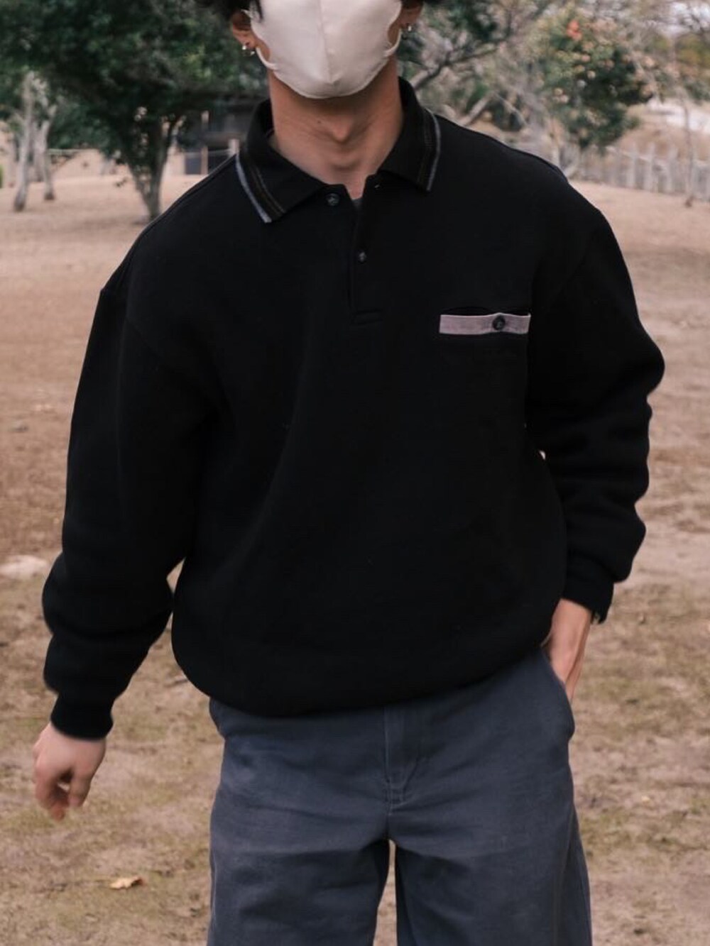 ブラック系のポロシャツ、グレー系のその他パンツ、ブラック系のスニーカーを着用したメンズの冬コーディネートの4枚目の写真