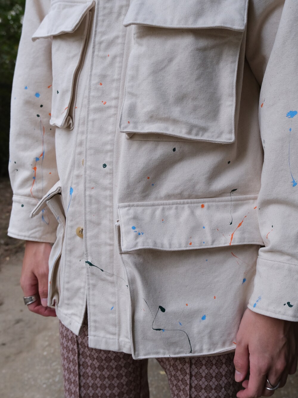 ホワイト系のカバーオール、オレンジ系のその他パンツ、ブラック系のローファーを着用したメンズの秋コーディネートの2枚目の写真