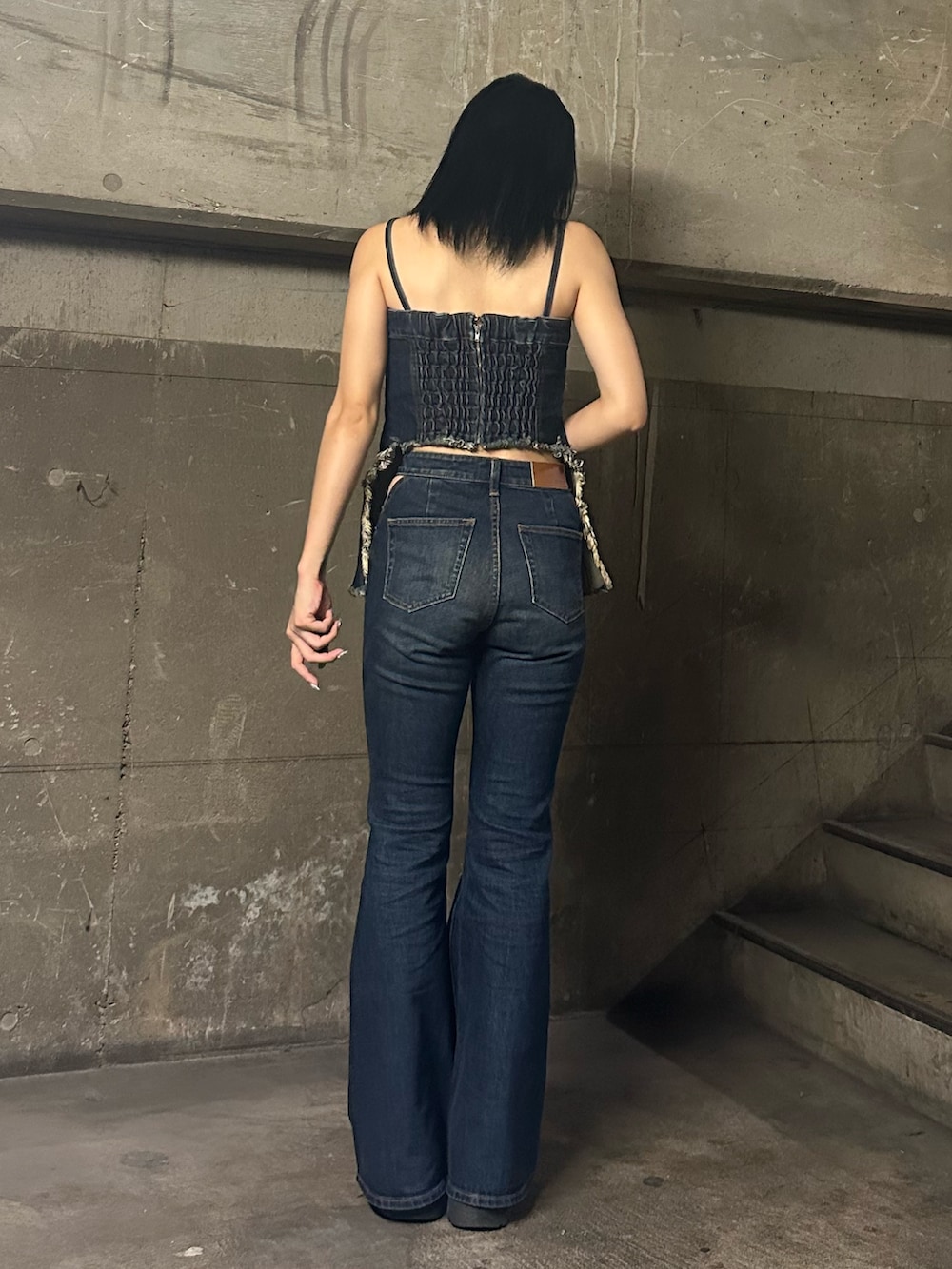 ブルー系のキャミソール、ブルー系のデニムパンツ、ブラック系のブーツを着用したレディースの夏コーディネートの3枚目の写真