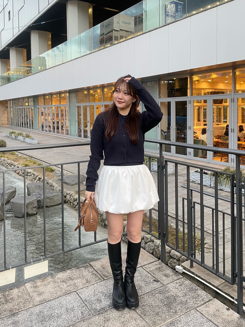 ブルー系のカーディガン/ボレロ、ホワイト系のスカート、ベージュ系のボストンバッグを着用したレディースの春コーディネートの5枚目の写真