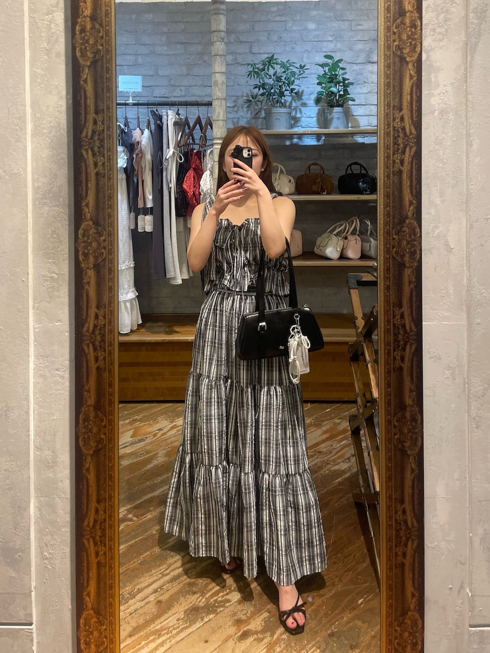 ブラック系のワンピース、ブルー系のデニムパンツ、ブラック系のボストンバッグを着用したレディースの春コーディネートの7枚目の写真