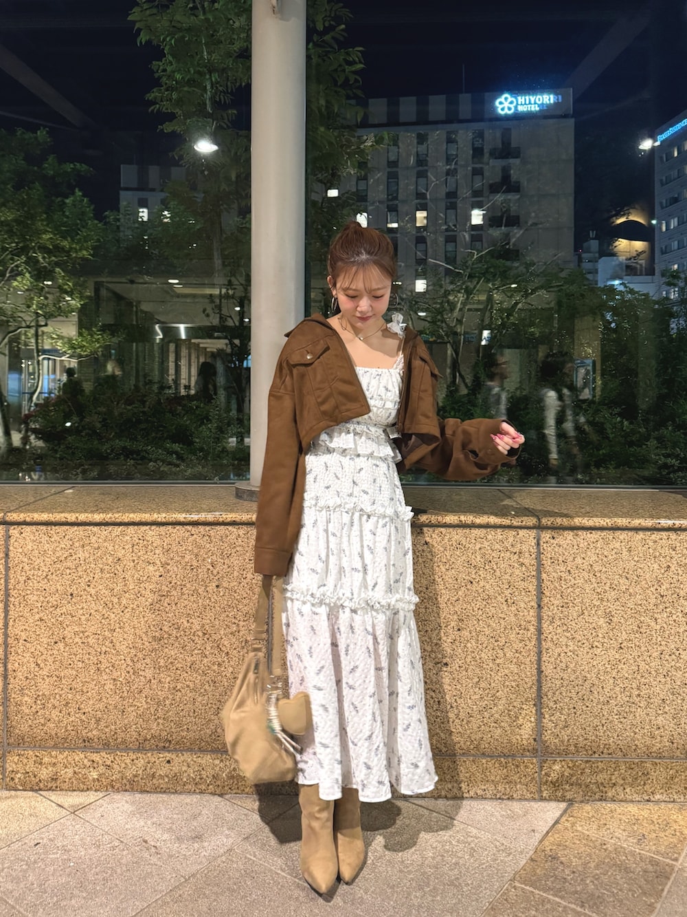 イエロー系のブルゾン、ベージュ系のショルダーバッグ、ホワイト系のワンピースを着用したレディースの春コーディネートの2枚目の写真