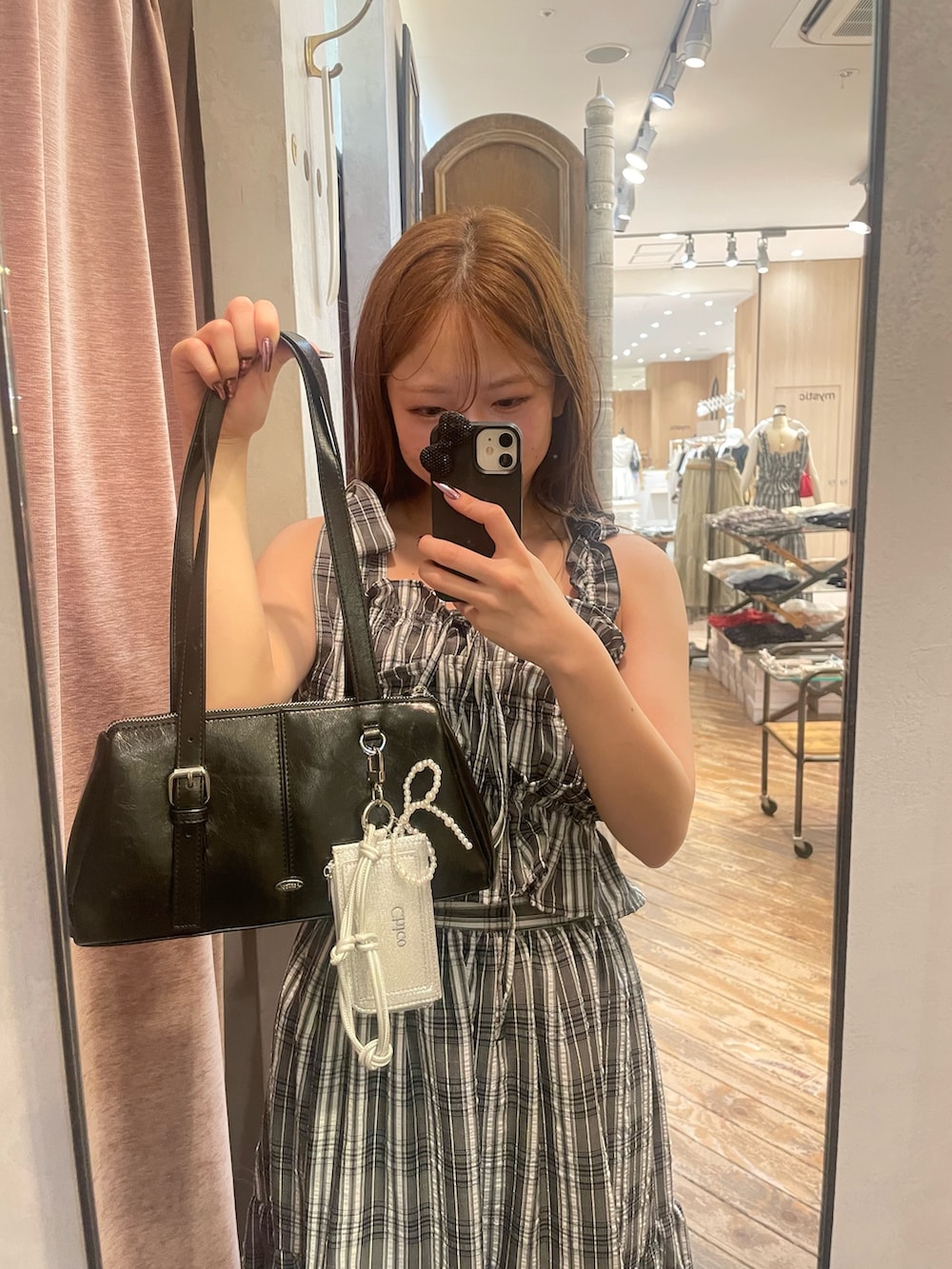 ブラック系のワンピース、ブルー系のデニムパンツ、ブラック系のボストンバッグを着用したレディースの春コーディネートの9枚目の写真