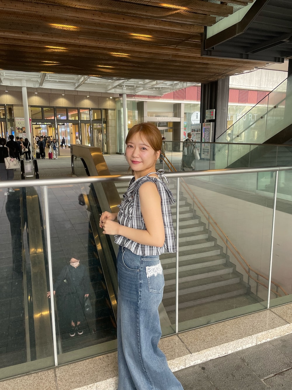 ブラック系のワンピース、ブルー系のデニムパンツ、ブラック系のボストンバッグを着用したレディースの春コーディネートの5枚目の写真