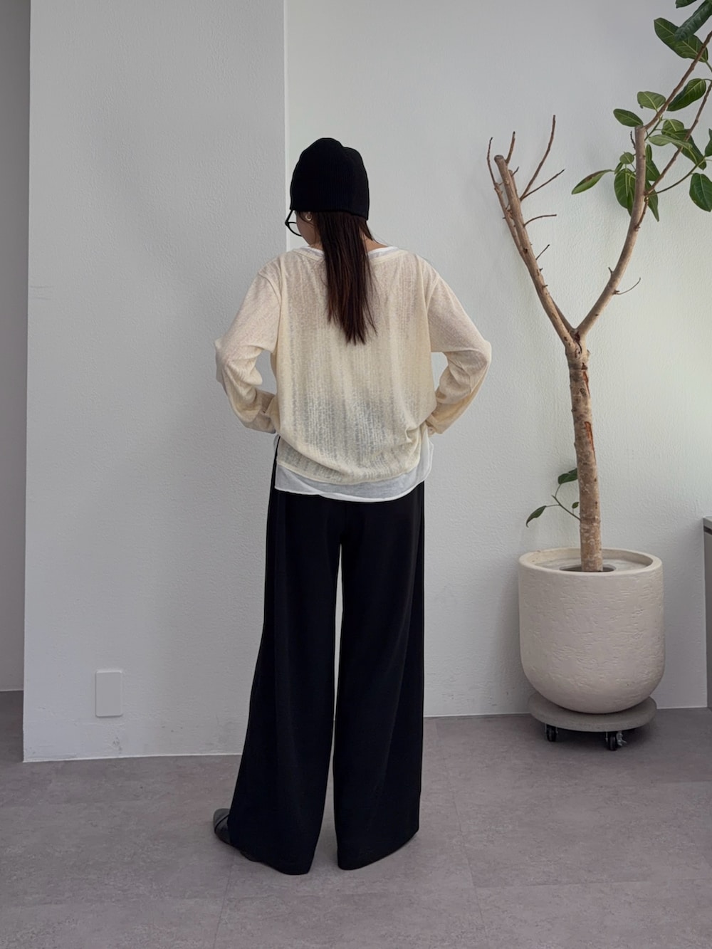 イエロー系のTシャツ/カットソー、ブラック系のスラックス、ブラック系のパンプスを着用したレディースの冬コーディネートの4枚目の写真