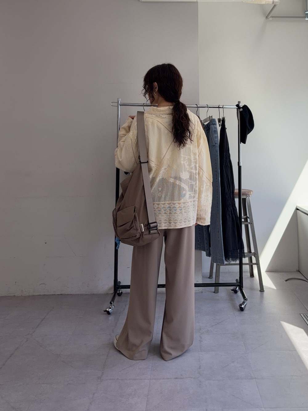 ベージュ系のスラックス、イエロー系のシャツ/ブラウス、ホワイト系のTシャツ/カットソーを着用したレディースの春コーディネートの3枚目の写真