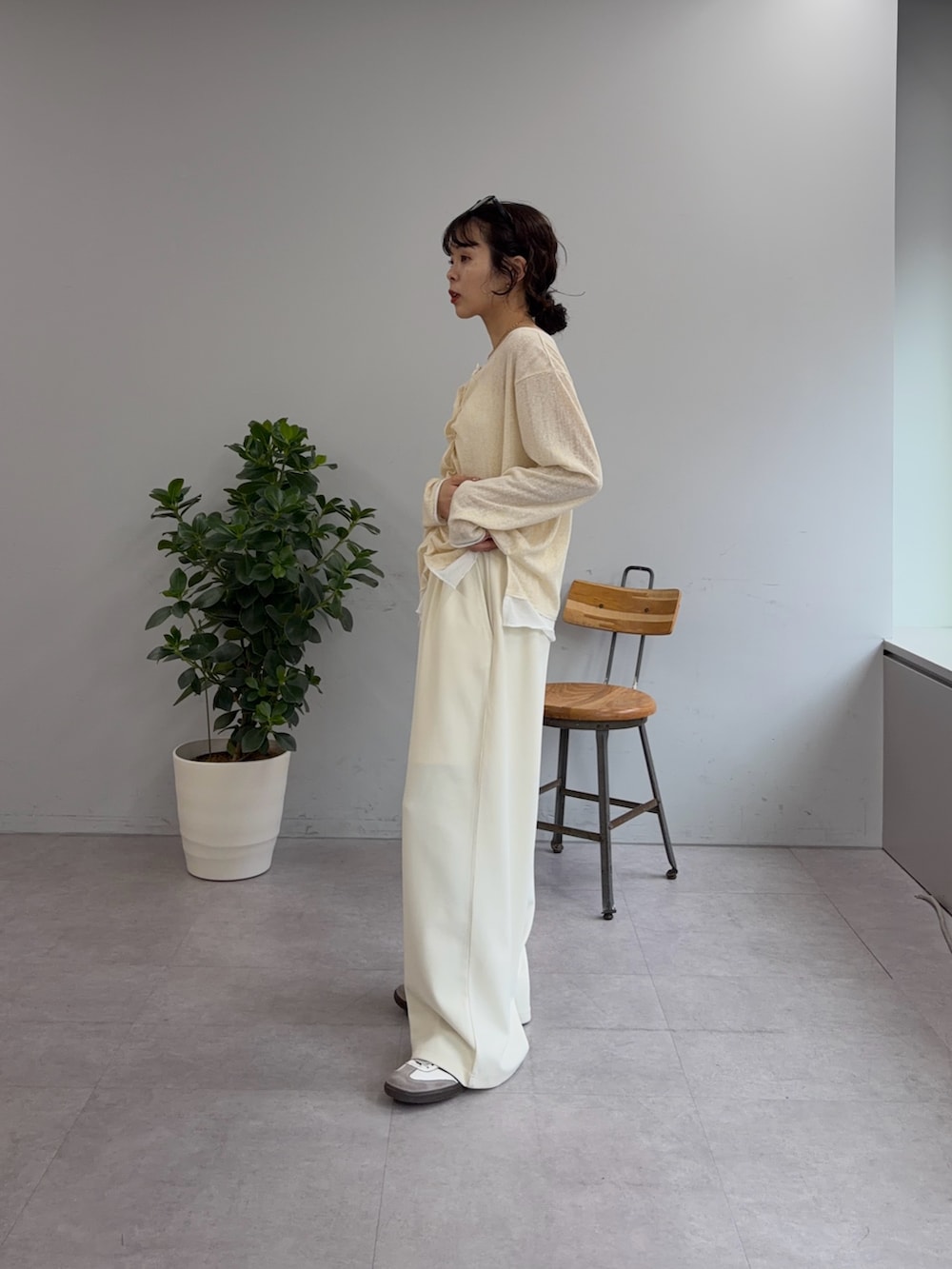 イエロー系のカーディガン/ボレロ、ホワイト系のスラックスを着用したレディースの冬コーディネートの2枚目の写真