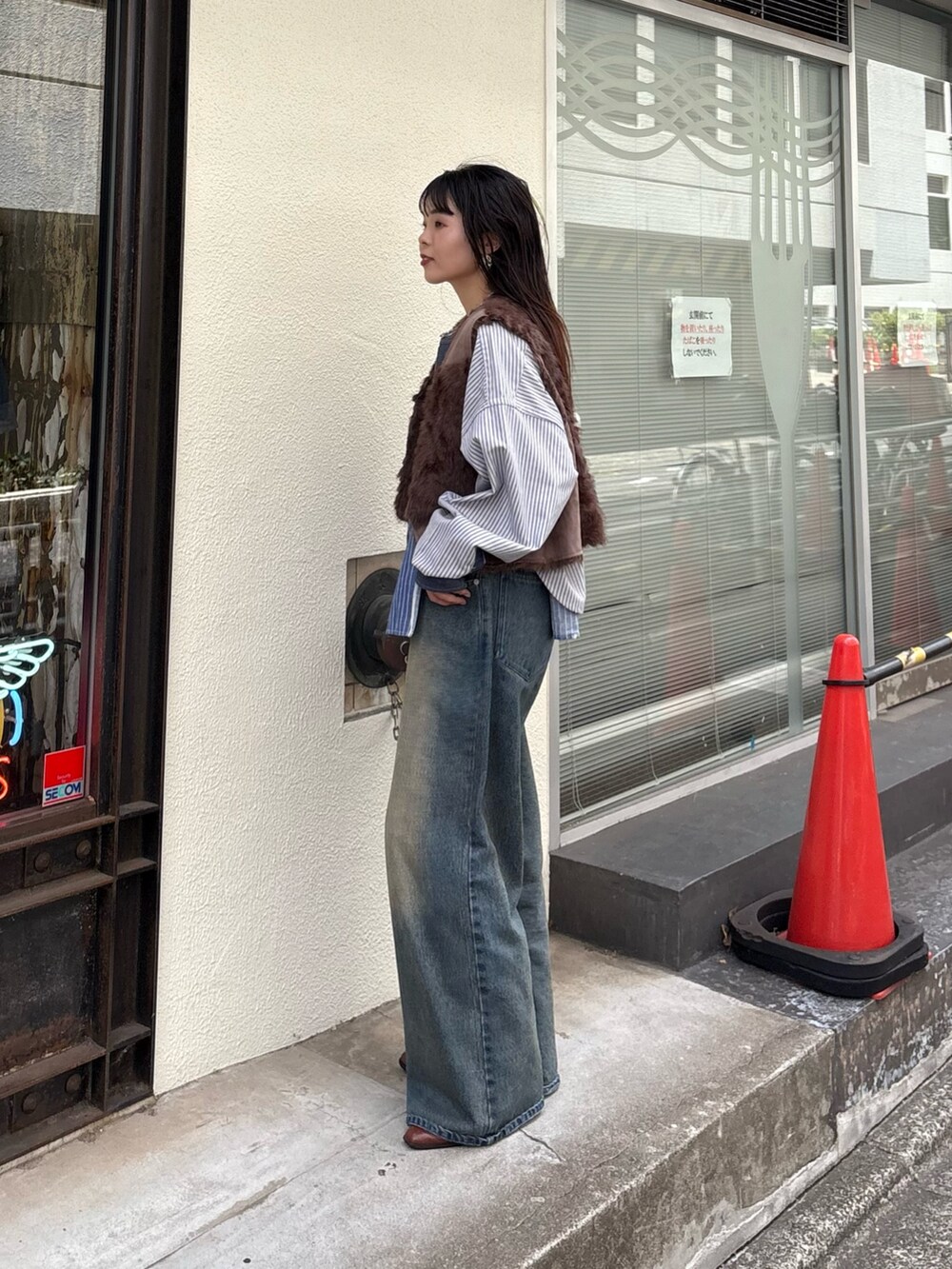 ブルー系のシャツ/ブラウス、ブラウン系のベスト、ブルー系のデニムパンツを着用したレディースの夏コーディネートの2枚目の写真