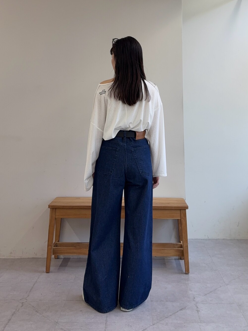 ホワイト系のTシャツ/カットソー、ブルー系のデニムパンツ、ブラック系のベルトを着用したレディースの春コーディネートの3枚目の写真