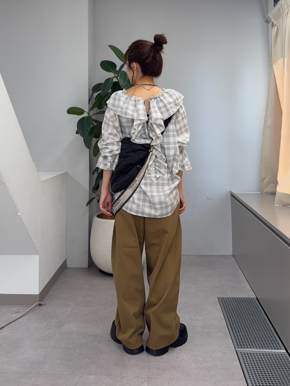 ホワイト系のシャツ/ブラウス、ブラック系のブーツ、ベージュ系のその他パンツを着用したレディースの夏コーディネートの3枚目の写真