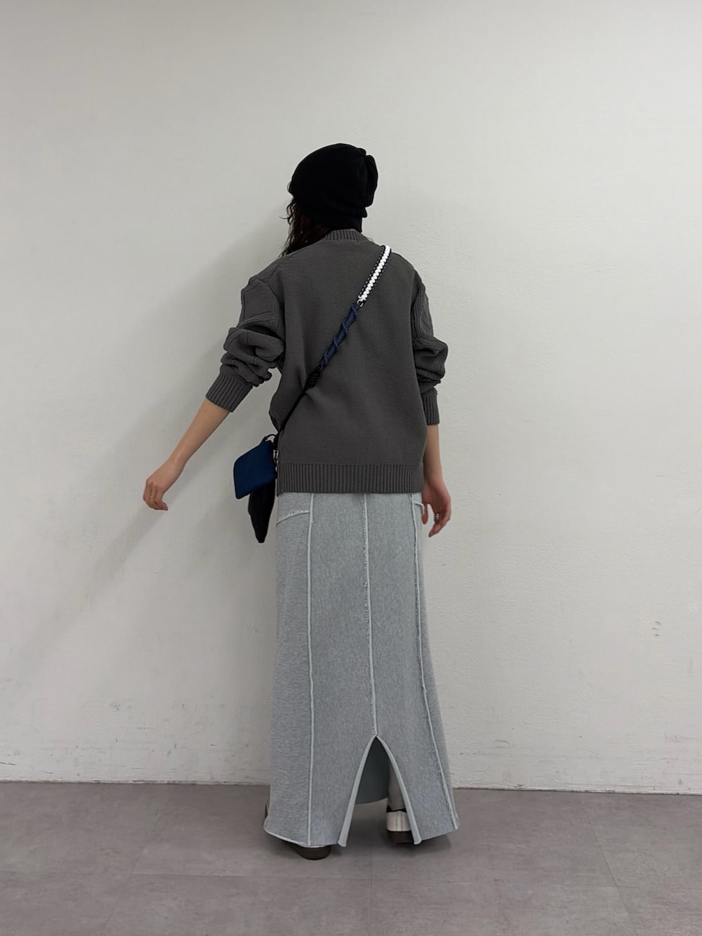 グレー系のカーディガン/ボレロ、ブルー系のスカート、ブラック系のショルダーバッグを着用したレディースの春コーディネートの3枚目の写真