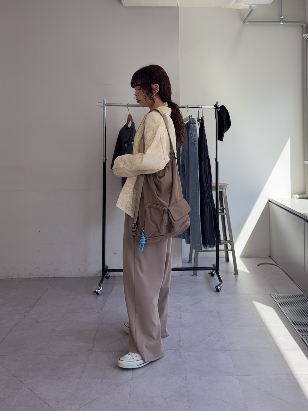 ベージュ系のスラックス、イエロー系のシャツ/ブラウス、ホワイト系のTシャツ/カットソーを着用したレディースの春コーディネートの2枚目の写真