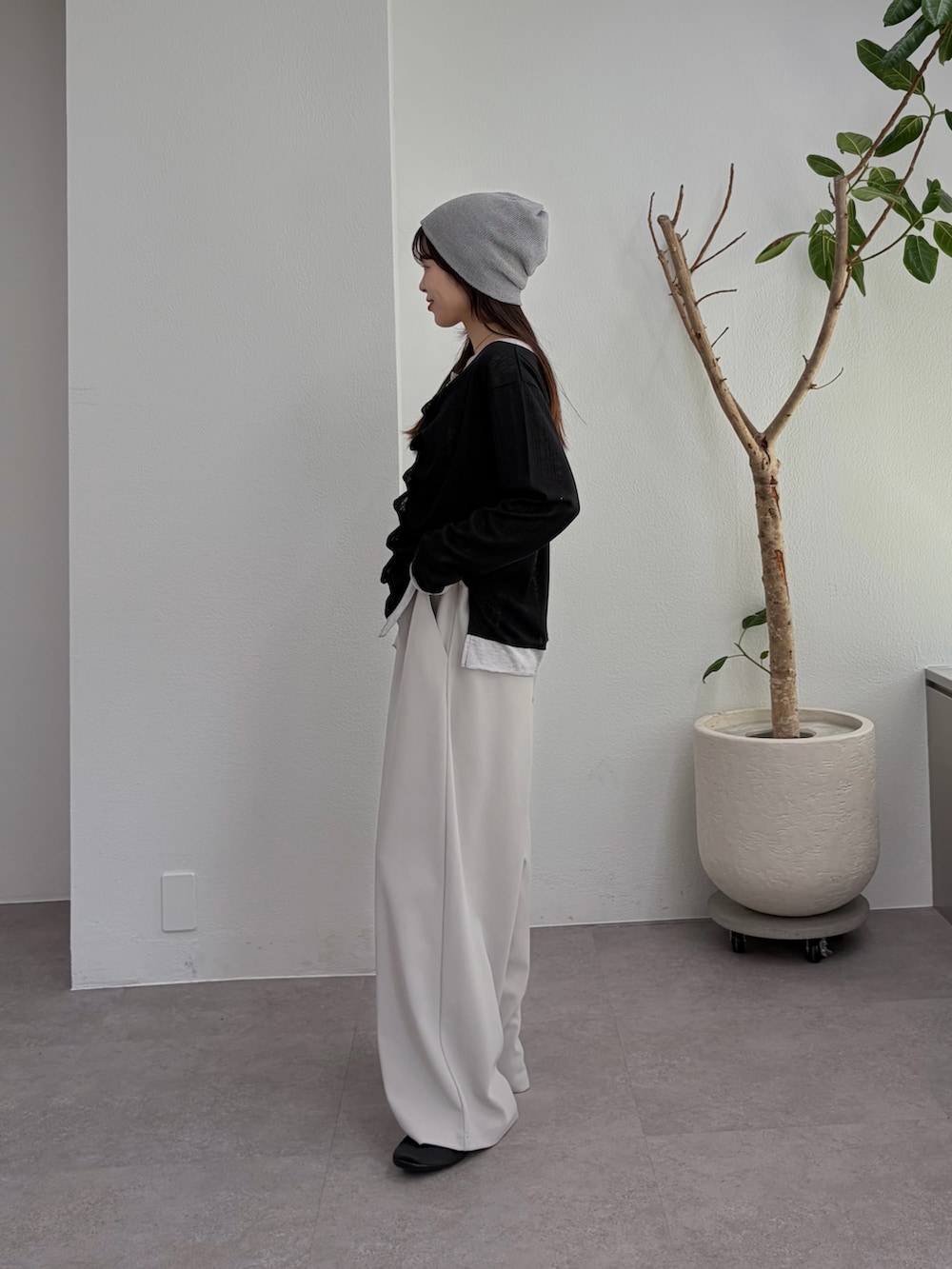 ブラック系のTシャツ/カットソー、グレー系のスラックス、ブラック系のパンプスを着用したレディースの冬コーディネートの2枚目の写真