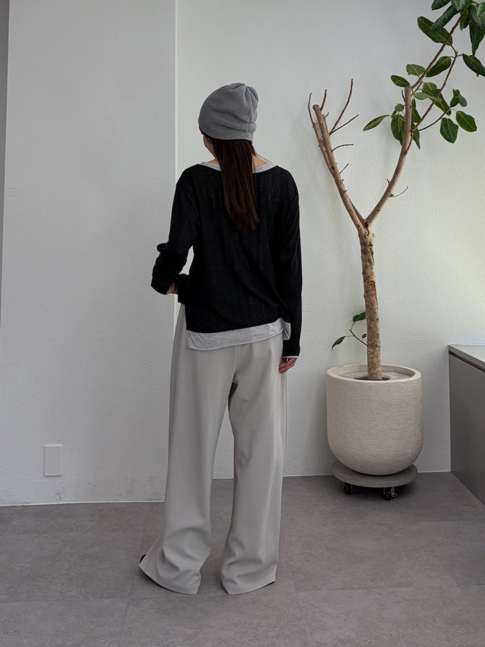 ブラック系のTシャツ/カットソー、グレー系のスラックス、ブラック系のパンプスを着用したレディースの冬コーディネートの3枚目の写真