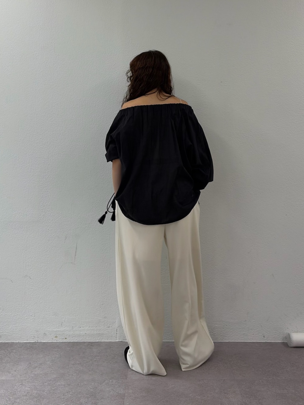 ブラック系のシャツ/ブラウス、ホワイト系のスラックス、ブラック系のスニーカーを着用したレディースの春コーディネートの3枚目の写真