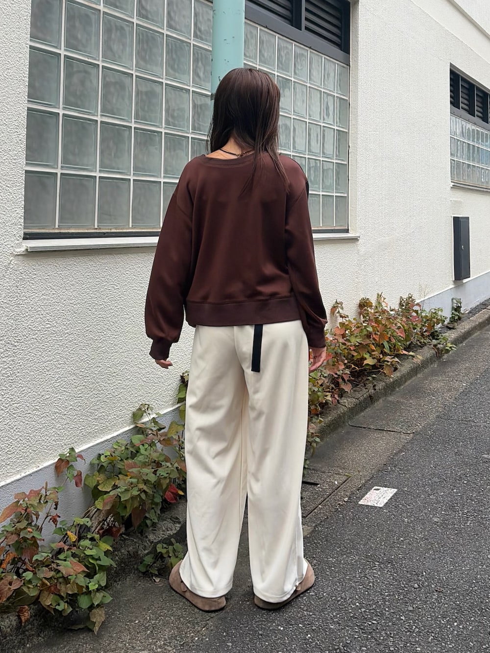 ブラウン系のカーディガン/ボレロ、ホワイト系のスラックス、レッド系のボディバッグ/ウエストポーチを着用したレディースの秋コーディネートの3枚目の写真
