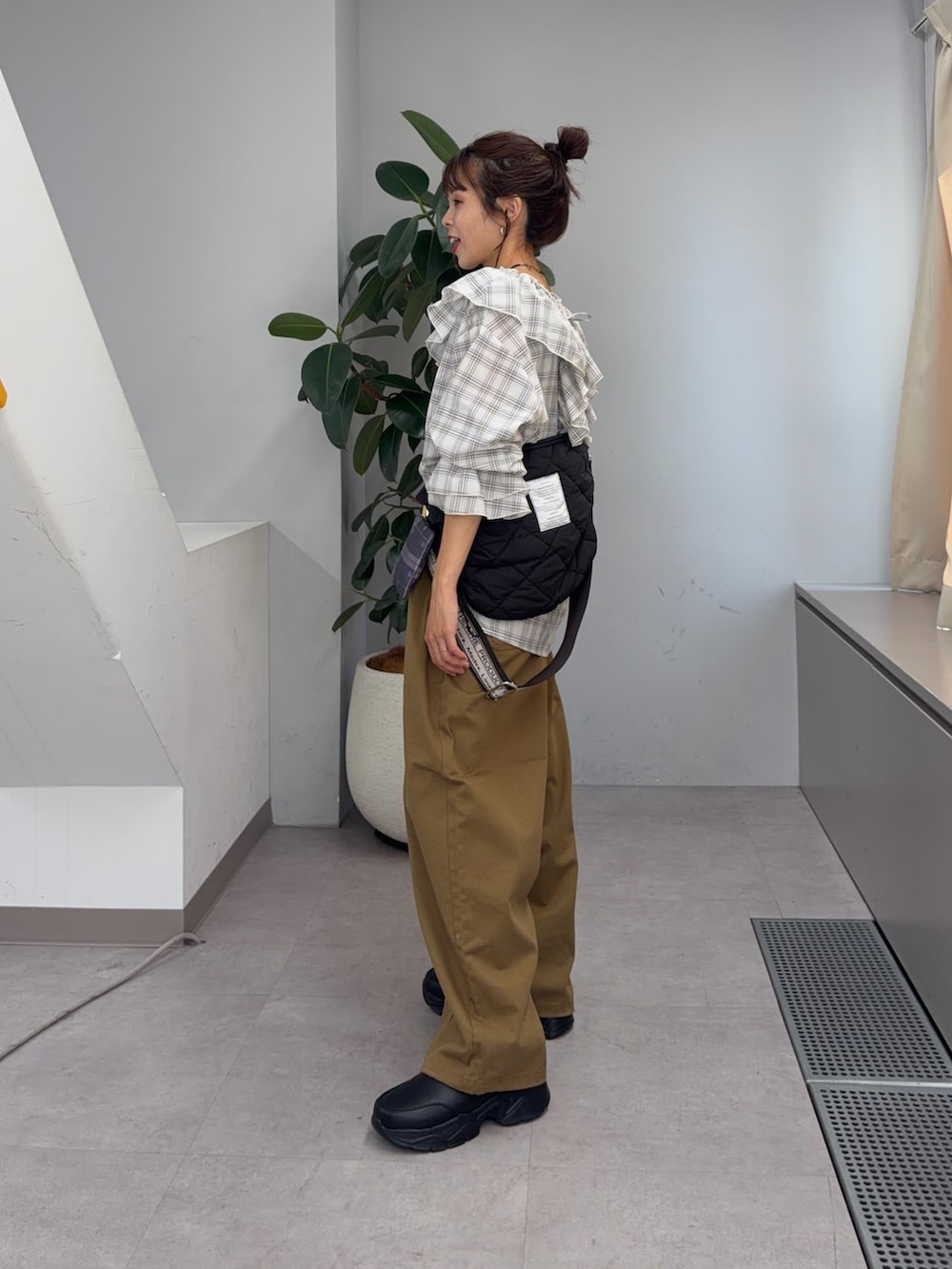 ホワイト系のシャツ/ブラウス、ブラック系のブーツ、ベージュ系のその他パンツを着用したレディースの夏コーディネートの2枚目の写真